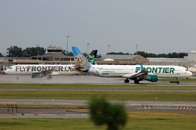 Airbus A321 (N708FR) - N221FR Frontier Airlines, Airbus A320-214, cn 3205 (Bugsy the Tree Frog) inbound to the gate behind FFT521, N708FR, A321-211, cn 7042 (Joe Bob the Badger), departing for Denver Int’l (KDEN) after a downpour at Cleveland-Hopkins Int’l (KCLE), USA – Ohio on 19 June 2017.