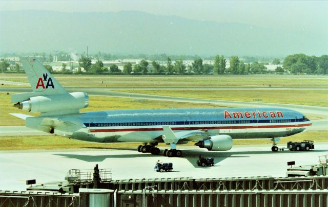 Boeing MD-11 (N1753) - KSJC - American MD-11 being repositioned to the north end of Terminal A for the loading and departure to Tokyo Narita, The flight usually left about 1-115pm daily. This day, MD-11 N1757A is left out of view at A-3, this back when for some reason, we'd have 2 MD-11s at the terminal - I never found out why. This was a great parking garage and view at SJC over the years opening in early 1990s when American has SJC as a Hub city with daily MD-80s back to back to back to back to back to back...got kinda boring and I have the video to prove it. When the AA 777-200 arrived it was really cool!