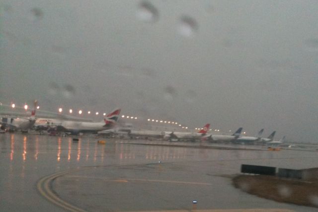 — — - A very wet international ramp.. a nice line up of various airlines and aircraft.