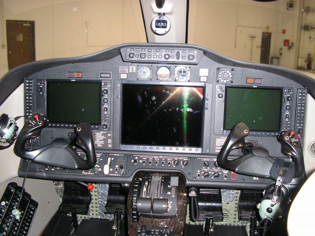 Cessna Citation Mustang (N510ND) - Registration pending to the University of North Dakota.  Cockpit view; notice the huge PFDs and MFD of the Garmin G1000 avionics suite, along with the fancy woodgrain trim around the throttle quadrant.  This jet is 1-pilot IFR rated.