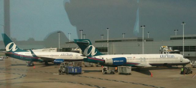 — — - Air Tran's two aircraft type at the gate... These birds will be wearing two different colors pretty soon...