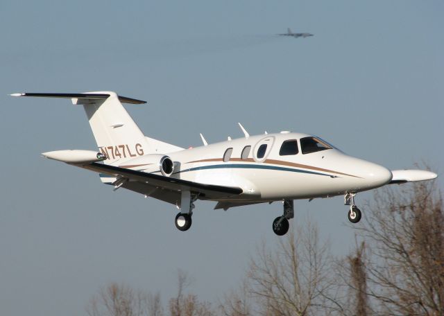 Eclipse 500 (N747LG) - 2008 Eclipse EA500 landing at the Downtown Shreveport airport with a mighty B52H on final for Barksdale Air Force Base in the background.