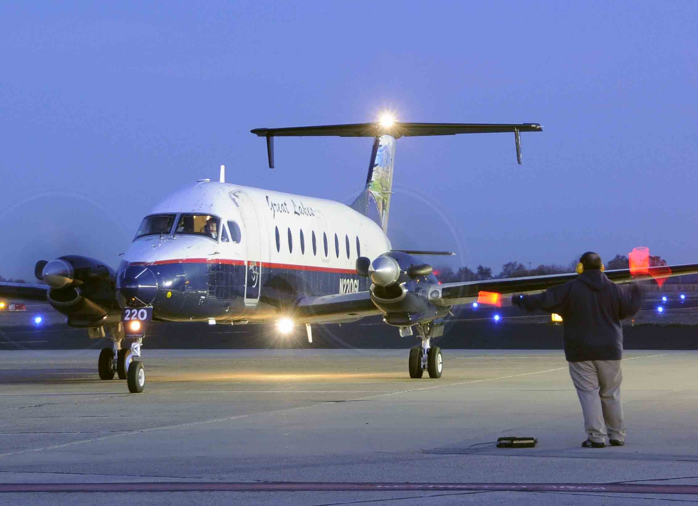 Beechcraft 1900 (N220GL) - GLA Station Manager Patrick marshaling the Beechcraft from the Merced terminal