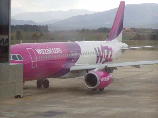 Airbus A320 — - A holiday snap from the window of the Girona Airport while waiting on a Ryanair flight.  I believe it's an Airbus A320-200.  The photo was taken in 2005.  The plane features the older Wizz Air livery.