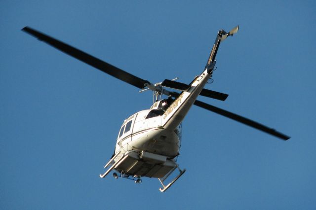 Bell UH-1V Iroquois (N911NV) - "Raven 3," the Washoe County Sheriff Departments Bell HH-1H-BF Iroquois helicopter, swoops past low and fast.  Moments later, it slowed over an empty field adjacent to the northeast perimeter fence of Reno Tahoe International.  There was nothing in the field; I know because I had just packed up my 8-foot ladder after a short aircraft spotting session in that same field and I had only driven past the intersection near the field when I saw Raven rapidly approaching from the north.  So, if anything WAS being sought in that field, it wasnt there anymore; Im 100%25 SURE of it. (BIG grin)