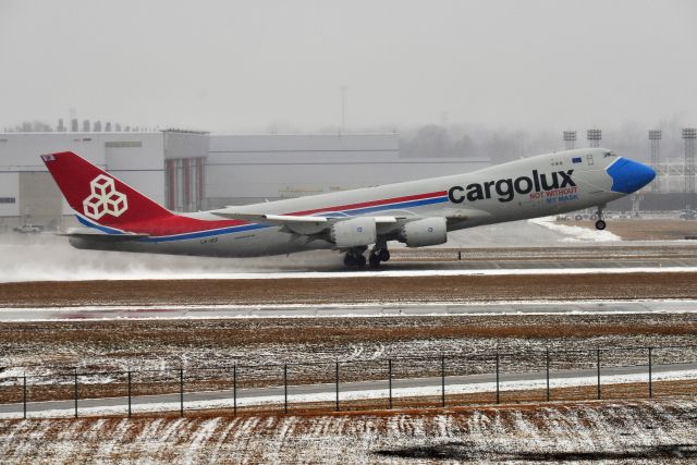 BOEING 747-8 (LX-VCF) - "Not without my Mask" departing runway 5-L on Sunday, 01-31-21. It was a nasty day in the slop. Ceilings were 400-500, visibility between 1.5-2.5 miles. Light Rain and Snow mix. Social distancing was maintained, and I wiped my hands with Clorox wipes after shooting this deparure.