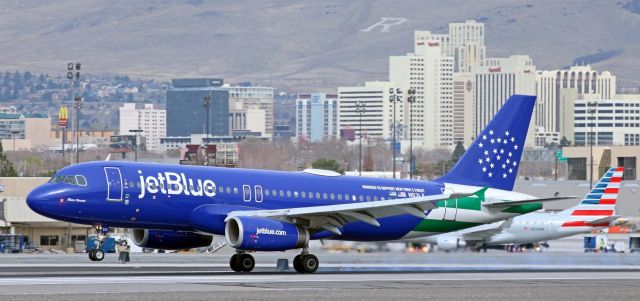 Airbus A320 (N531JL) - A heavily overcast midmorning but JBUs "Blue Finest" (N531JL), the A320 with the special livery that honors the men and women of the NYPD, still stands out against the downtown Reno city as it touches down on 16R to complete the daily KLGB-KRNO run.