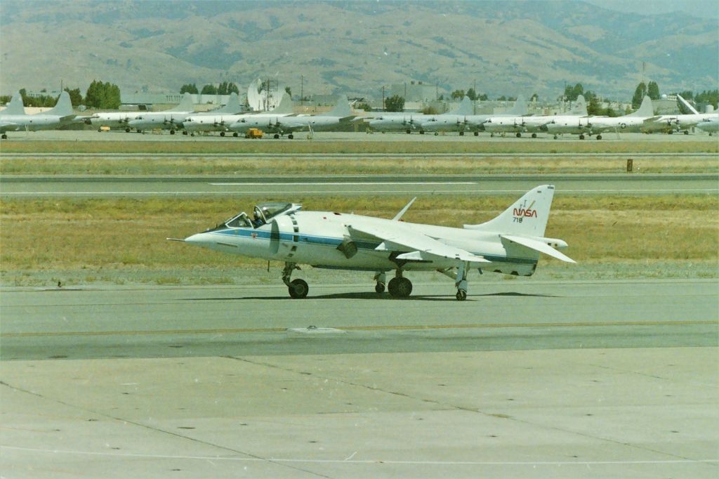 — — - KNUQ - NAS Moffett Field in July 1989 Airshow weekend - NASA's Harrier #719 rolling back to the ramp - this back when NAS Moffett had a "2 day" Airshow and the Blue Angels would draw huge crowds. Friday night fly-in's were easy to capture from the frontage road by Hwy 101 that alone would draw hundreds of people. The Airshow was free admission but $3.00US to sit in the viewing stands, in which I was always 1st in line when they opened and got the far north end seat, top level to keep all of the 'spectator heads" out of my camera view. I bet parking all of the P-3 Orions in the distance was fun! Back in the 1960s, my Dad knew a guy around the corner in San Jose, and he was a P-3 Pilot or Wing Comander, and my dad volunteered me to baby-sit his 2 kids when I was about 14-15yrs old. I never wanted to baby-sit kids, but Dad made me to save face since he said I'd do it before he asked me. The P-3 Pilot had a dark blue MGB and he'd give me a ride home at 02:00am and being almost 6'4" it was tough to climb into - but he was an almost twin of the Carrier Captain in the original "Top Gun" movie......so long ago.