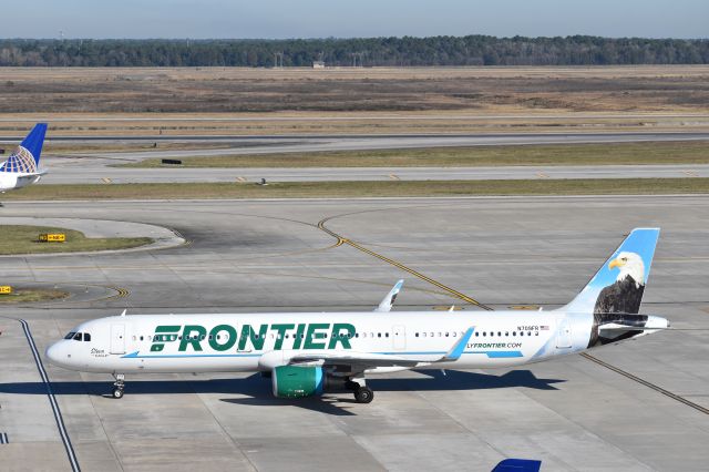 Airbus A321 (N709FR) - Picture taken of Frontier Airlines' Steve the Eagle (N709FR) Taxiing to gate A11 at Houston IAH, TX, taken from parking lot. br /Picture by David Rosario III