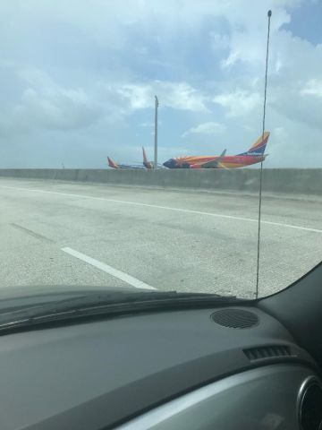 Boeing 737-700 (N955WN) - 2 Crayola styled WN 737s and Arizona 1 at 28L for takeoff, oh the car in the picture was a write off