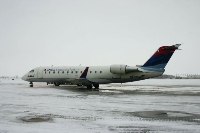 Canadair Regional Jet CRJ-200 (N438SW) - Photo from January 13, 2012; photo taken on a snowy afternoon inside the Saginaw-Bay City Regional Airport terminal. I think this is the last time I saw the "Colors in Motion" livery on Deltas (operated by SkyWest) jets.