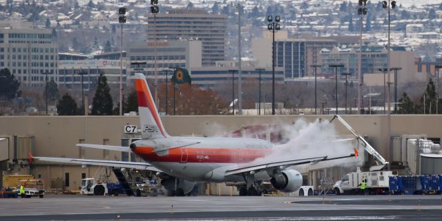 Airbus A319 (N742PS) - An "Iceman" team removing a thin coat of frost acquired during an overnight stay.  Only took a few moments and AA's PSA Heritage liverybird was ready to push all the way back into the alley and taxi for departure.