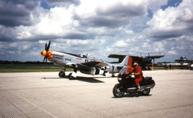 North American P-51 Mustang — - April 2002 Chuck Yeager taxis his aircraft at Lakeland, Florida. Motorcycle is following to keep onlookers and other aircraft clear. Scanned from print.