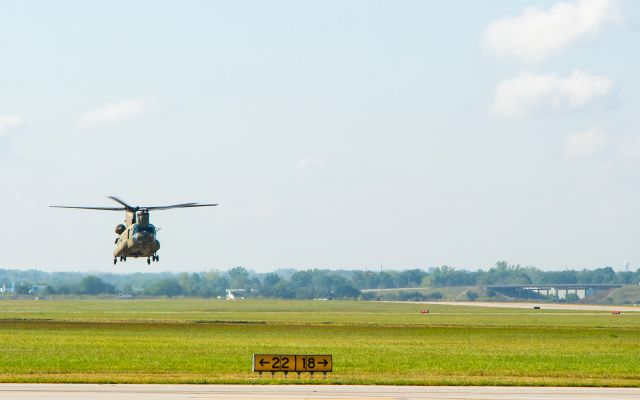 — — - Chinook with Learjet on runway behind.