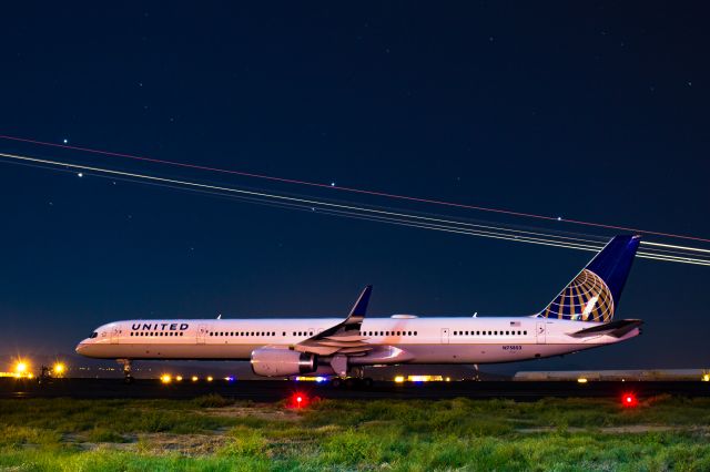 BOEING 757-300 (N75853) - A united 757 sits quiet on the ramp at Atlantic Aviation in Tuscon Arizona. This particular airplane earlier had carried in the UCLA football team. The streak is a C-130 performing a go-around on runway 11L.br /br /a rel=nofollow href=http://www.ThePilotsEye.comwww.ThePilotsEye.com/a