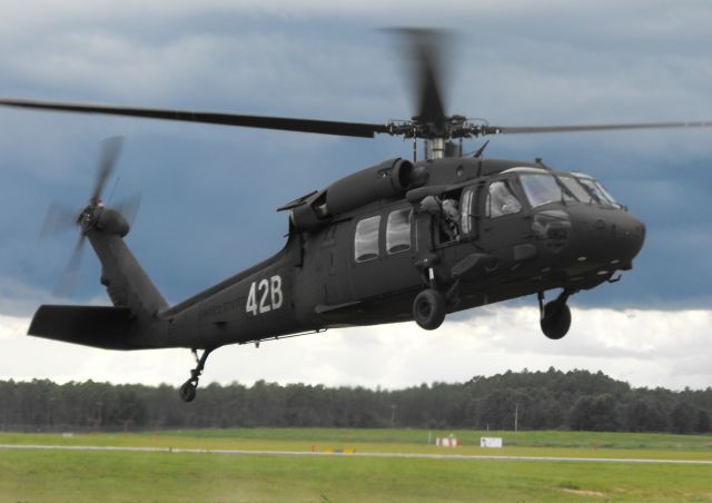 Sikorsky S-70 (02-6242) - 42B lifting off the pads with a crew member watching for obstructions.