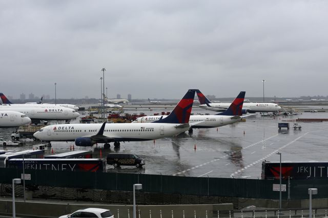 Boeing 737-800 (N395DN) - Passing the Delta Terminal on the Airtrain.  A long queue of planes for departure on 04L in the background including Etihad A380 A6-APD.  20 planes in the view