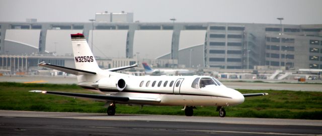 Cessna Citation V (N325QS) - Taxiing to 30-L for Take Off  (Large building in background, New Parking Garage near New Terminal B)