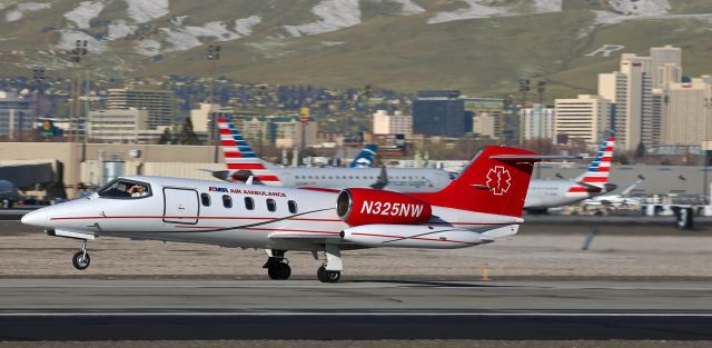 Learjet 35 (N325NW) - The pilot shields his eyes from the sun as he rotates N325NW off Runway 16L.