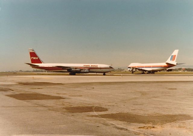 Boeing 707-100 — - TWA B-707 ready for take off with a United B-747 on take off roll in the back ground at KLAX spring 1977