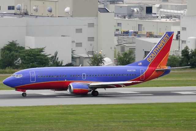 BOEING 737-300 (N387SW) - Seen at KBWI on 7/11/2009, this aircraft was involved in an explosive decompression incident two days later, on 7/13/2009.  A football-sized hole opened up just in front of the vertical stabilizer.  It was operating as WN2294 from KBNA to KBWI, and made an emergency landing in KCRW.  No injuries.  (it was dark & overcast that day, so the photo is average)