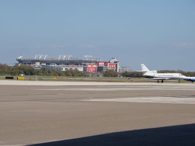 — — - Tampa Bay Bucs football stadium behind Falcon parked on the ramp.