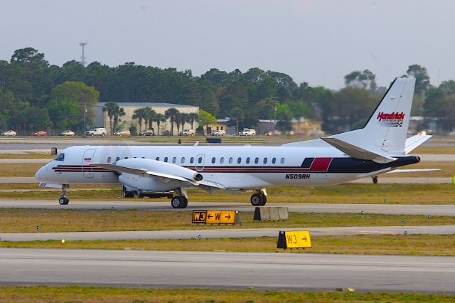 Saab 2000 (N509RH) - 509 taxis out to 7L after the Daytona 500. The benefit of flying over driving clear here with the line of cars exiting the speedway clearly visible in the background.