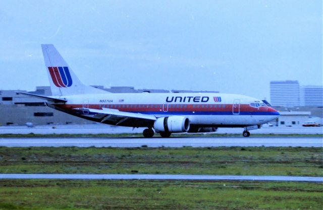 Boeing 737-500 (N927UA) - KLAX - Jan 1998 United 737-500 rolling out on 24R at Los Angeles - this was/is? a great angle when the sun was setting in the west - though fairly accessible to photo from 1998 wise, it was not a friendly parking area. Noon day sun this was not real good looking towards the Sun. I am not sure where the -500 was arriving from but most likely West Coast operations jet.