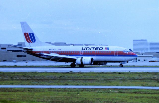 Boeing 737-500 (N927UA) - KLAX - Jan 1998 United 737-500 rolling out on 24R at Los Angeles - this was/is? a great angle when the sun was setting in the west - though fairly accessible to photo from 1998 wise, it was not a friendly parking area. Noon day sun this was not real good looking towards the Sun. I am not sure where the -500 was arriving from but most likely West Coast operations jet.