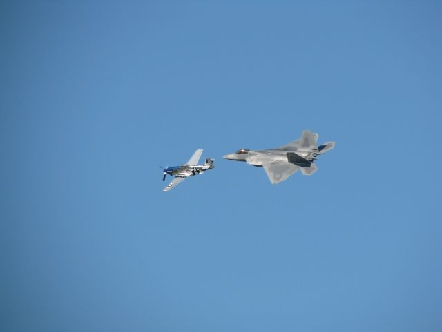 — — - P-51 Mustang and F-22 Raptor fly formation at Oshkosh 2008.