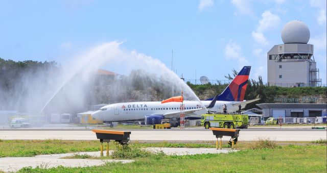 Boeing 737-700 (N310DE) - Delta departing pilots getting a water canon salute on his last pass at TNCM St Maarten.