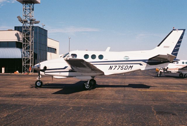 Beechcraft King Air 90 (N775DM) - Beechcraft C90 King Air, msn LJ-764, manufactured in 1978 and photographed at KLFT, Lafayette Regional Airport. N775DM had just arrived and is taxiing at Paul Fournet Air Services FBO facility. The photo was taken circa year 2000 with a Canon 35mm film camera.