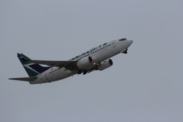 Boeing 737-700 (C-GWSE) - Take off.  Shot from corner of Brookside Blvd and Notre Dame Ave.  De-iced.