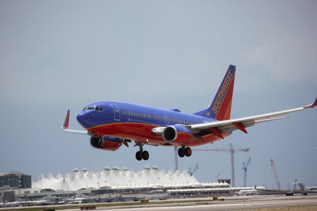 Boeing 737-700 (N956WN) - Landing on 34R with DIA terminal in the background.