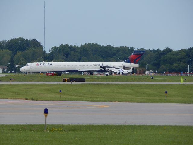 McDonnell Douglas MD-90 (N903DA) - A Delta MD90 prepares for takeoff as a P-51 Mustang comes to land next to it at the 2014 Rochester Air Show.