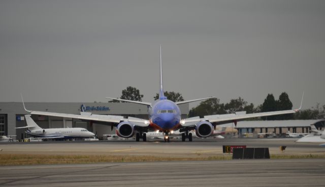 Boeing 737-700 (N967WN) - This Southwest 737 is seen turning off of runway 20R at taxiway "echo". Photo was taken in the West Coast Charters parking lot.