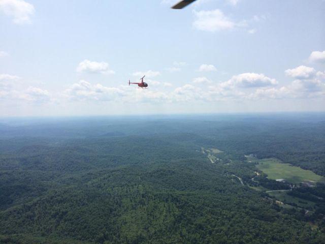 Robinson R-44 (N133CC) - Paul Salmon and Terry Underwood out over the trees near Branson, MO