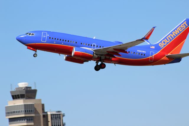 Boeing 737-700 (N963WN) - Taking off from MSP on Sunday June 4 with blue skies. Tower in the background. 