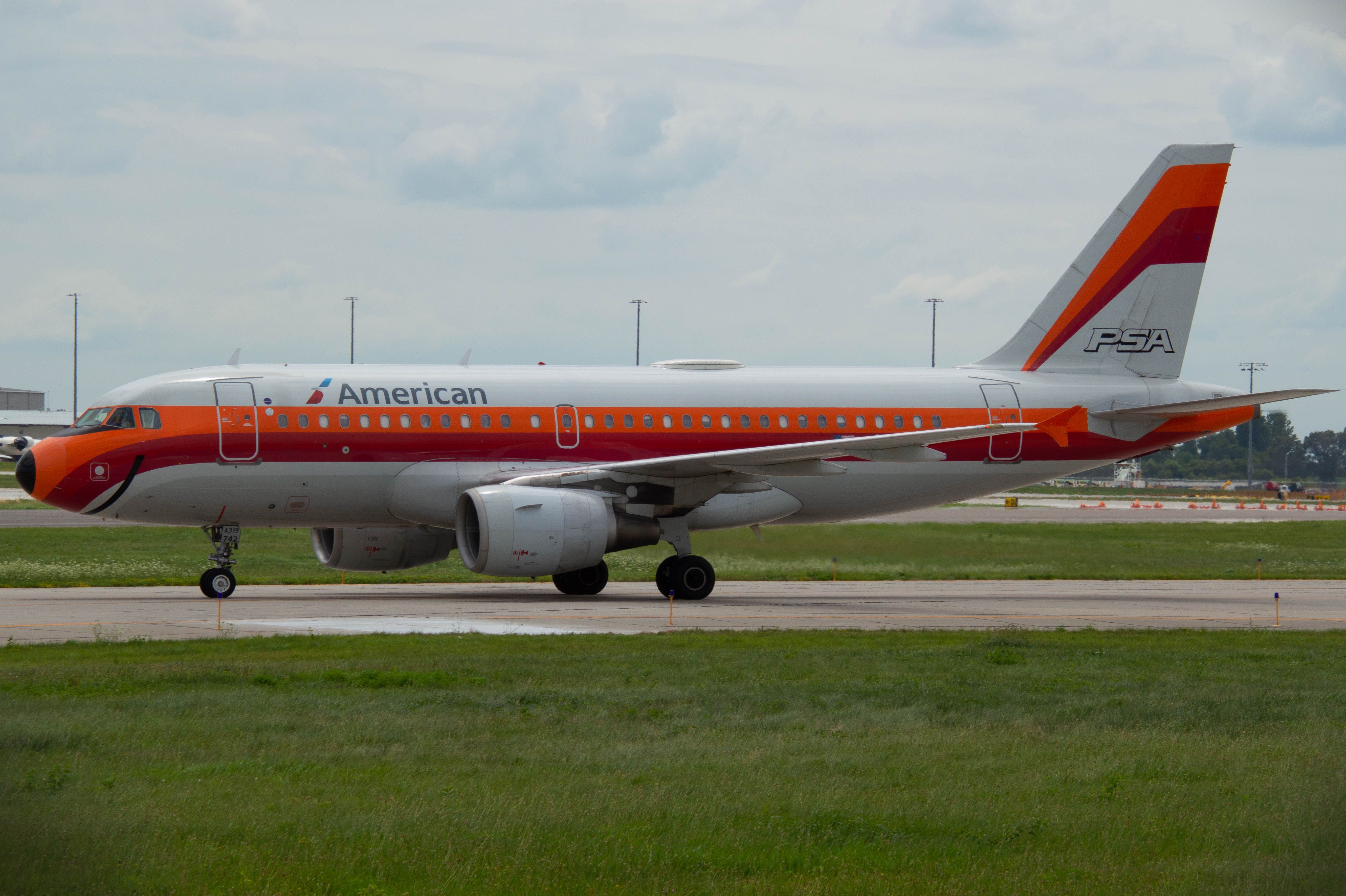 Airbus A319 (N742PS) - The PSA "Smile Jet" Retro taxies by me on here way to Gat A5 at DSM just after a nearly 3 hour flight from Phoenix as AAL 2014. Photo taken July 30, 2020 at 1:52 PM with Nikon D3200 at 100mm.