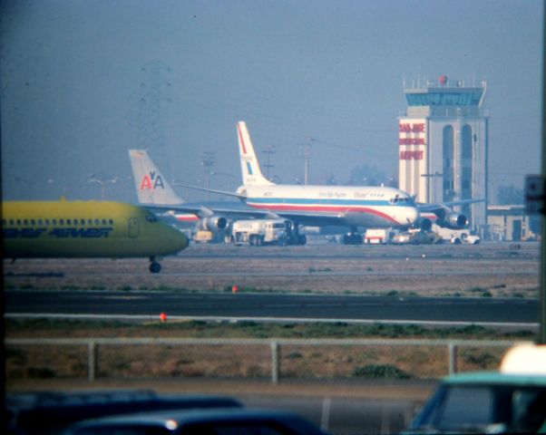 — — - KSJC - mid 1970s photo at San Jose, CA on a murky/hazy/froggy day shows two rare birds at the time, at SJC. SFO diversion traffic due to poor visibility at SFO brought two freighters in. This was taken with a 600mm lens from the old dirt parking/viewing lot on Airport Blvd off Coleman Ave by the old Chevron gas station. View looking north/northeast. There is an American Airlines 707 behind the United DC-8F. I also have a TWA 707 freighter at SJC posted also, same day.