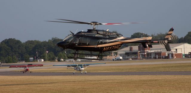 Bell 407 (N617HC) - N617HC assigned a parking place after following taxi rules, two aircraft behind him will be moved to the far end of the runway