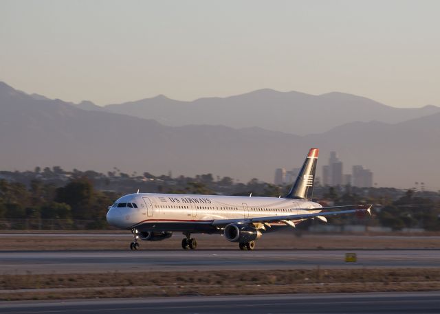 Airbus A321 (N524UW) - This US Airways Airbus A321 is taking off from runway 24 Right at LAX. This photo was taken at sunrise, 07:35 am, 6 Nov 2013, an unusually clear day. Downtown Los Angeles can be seen 20 miles away in the background. br /br /Los Angeles is the only planet you can drive to on a freeway. On an average morning it takes about an hour to drive to downtown LA through a maze of traffic-choked freeways.