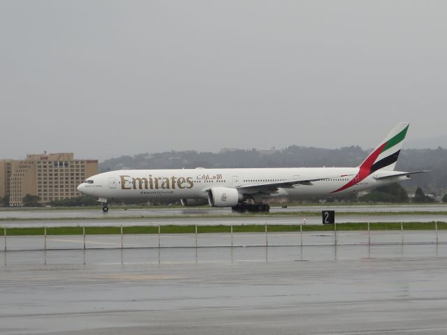 BOEING 777-300 (A6-ECK) - EK226/h taxiing to rwy 28L as it crossing both runway 01L&R at SFO in this raining day.