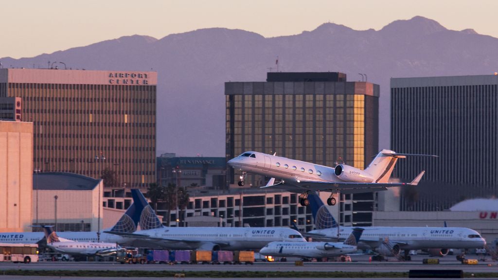 Gulfstream Aerospace Gulfstream IV (N450EE) - This pretty Gulfstream has broken into the morning sunshine at LAX, Los Angeles, California USA. How would you prefer traveling to work, by G-IV or one of the other choices seen below it? 