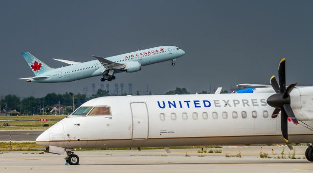 Boeing 787-9 Dreamliner (C-FGDZ) - ACA61 climbs out of YYZ on her way to Incheon, a 12.5 hour flight over the Pole. In the foreground sits an ex-Republic Airlines DH8D (N188WQ) which looks like its being parted out… one of several United Express Dash-8s sitting on various ramps at YYZ