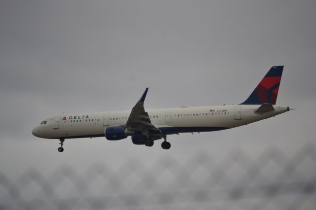 Airbus A321 (N104DN) - In employee parking lot north of fuel farm