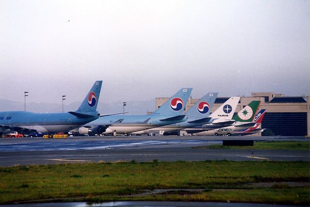 Boeing 747-400 (HL7472) - KLAX- Nov 1998 view after an early AM rain shower we saw 3 KAL 747 400 series at the Intl Dock which was very rare at the time. The VARIG was a 747 300 and the LAN Chile was a Boeing 767 200.