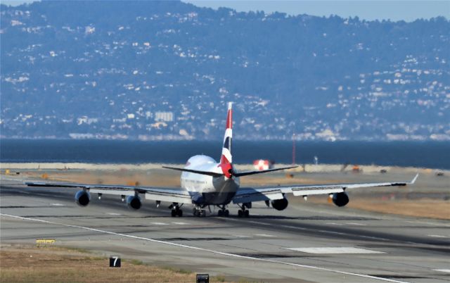 Boeing 747-400 (G-CIVX) - KSFO - British 747-400 departing 1R at SFO due to a American A321 blocking the taxi way to the right out of view - rare treat for me to see the 747 use this runway. photo from the top of the BART garage.