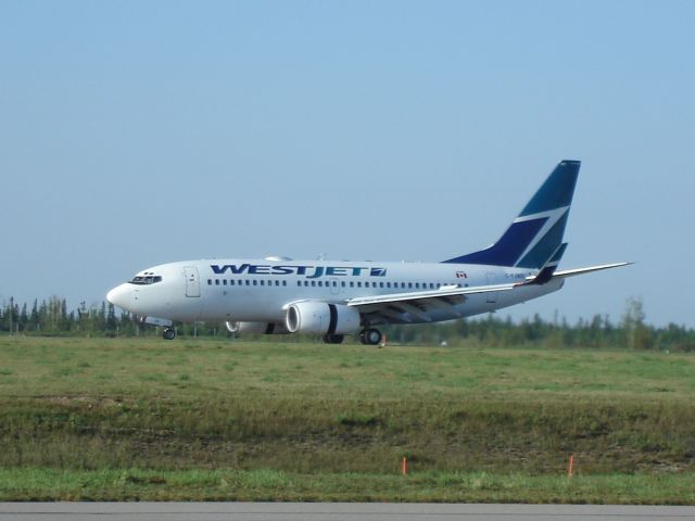 Boeing 737-700 (C-FJWS) - WestJet Boeing 737-700 lands with the reverse panels visible at Fort McMurray, Alberta, Canada on Friday, August 8th, 2008