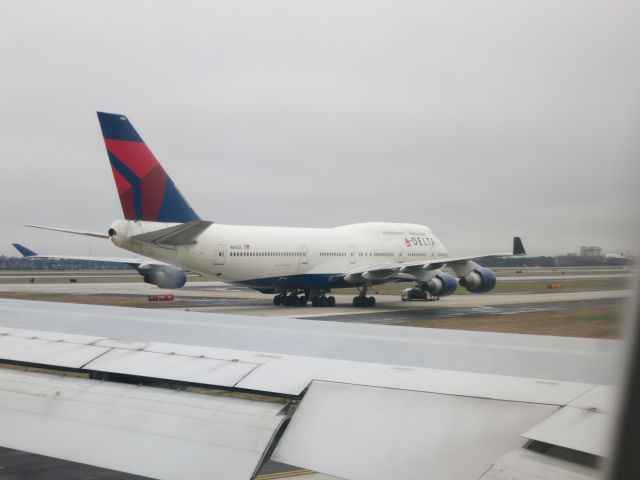 Boeing 747-400 (N661US) - Delta Airlines 747-400 about to be towed across runway 9L/27R at KATL. Photo taken from Delta Airlines 767-300 N171DZ (Habitat for Humanity).